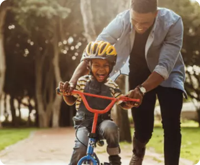 Father holding his kid bicycle and trying to teach him how to drive it